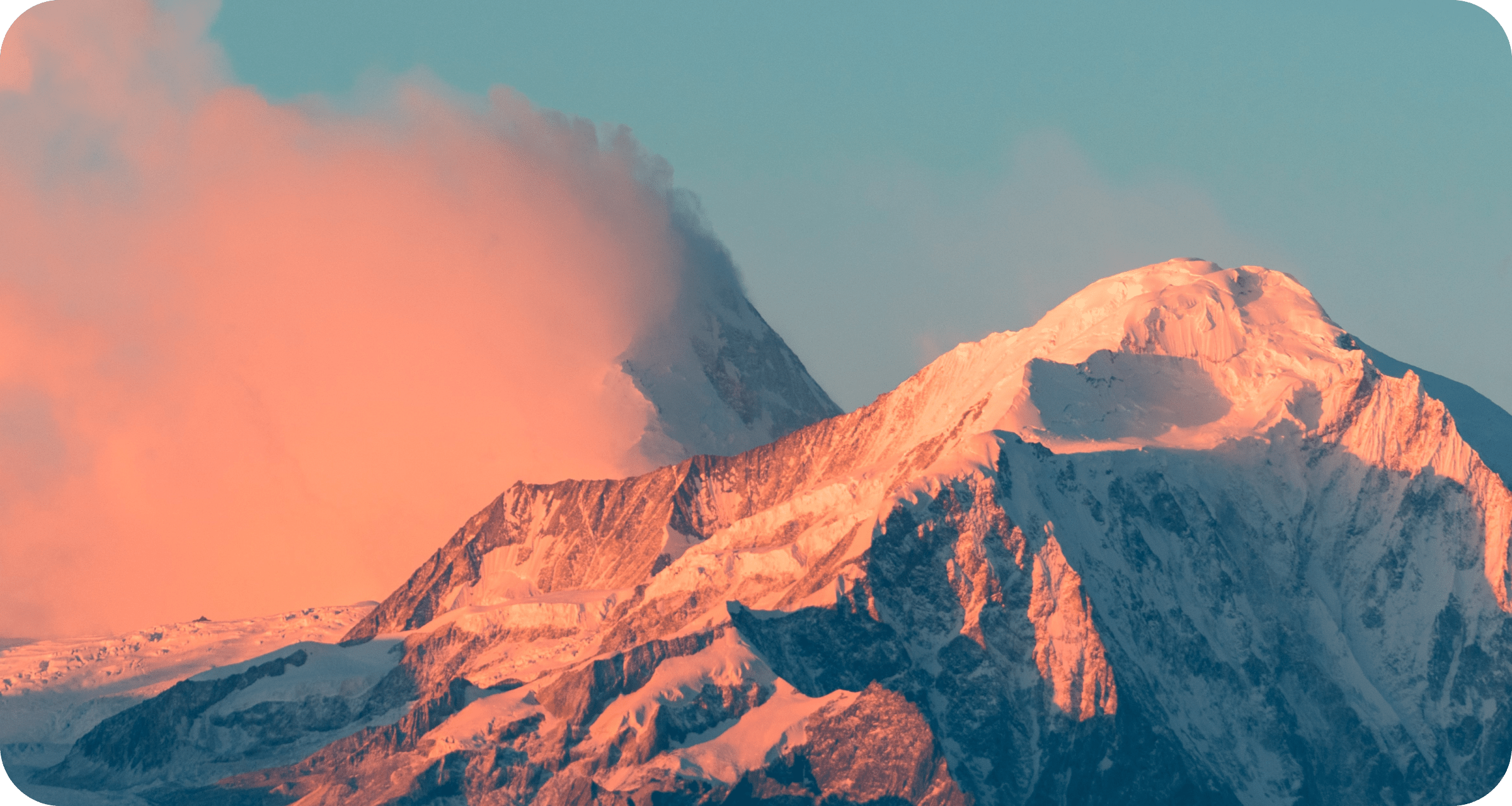 A mountain peak at sunrise, with pink lighting